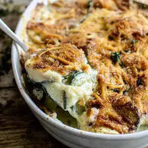 zucchini gratin being scooped from a white dish