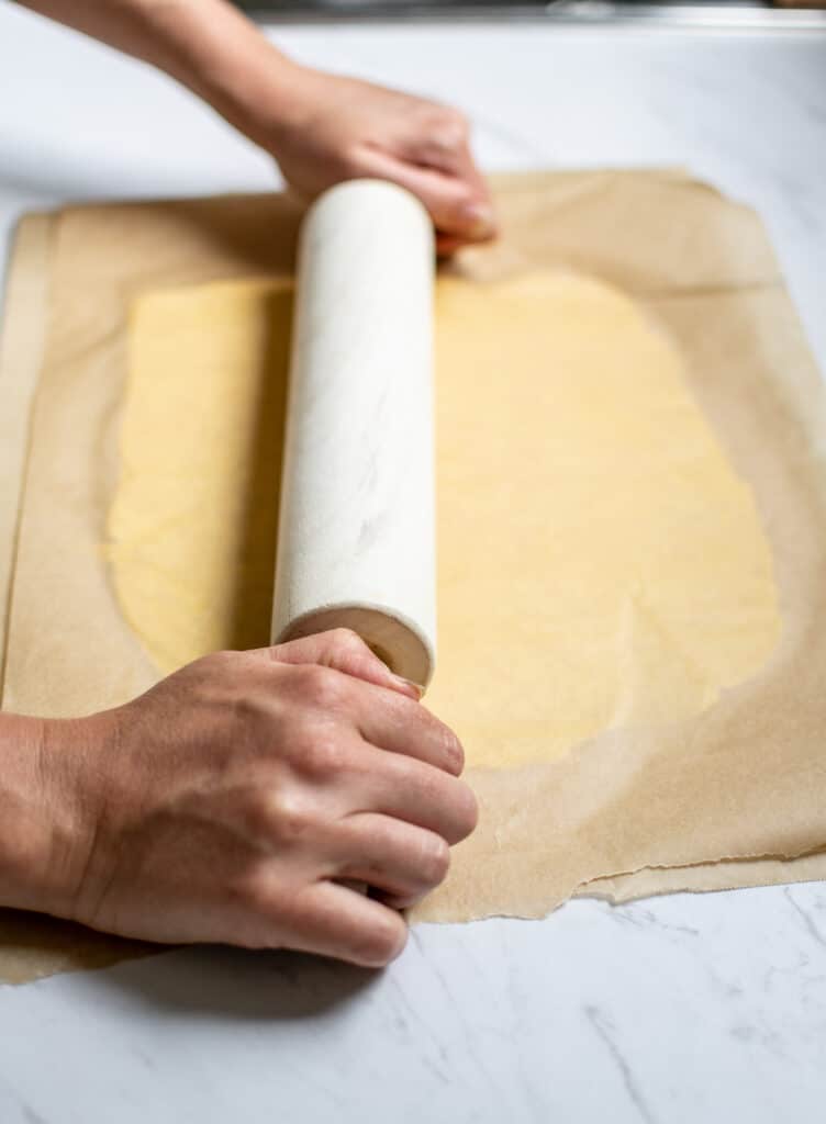 Butter being rolled out between baking paper