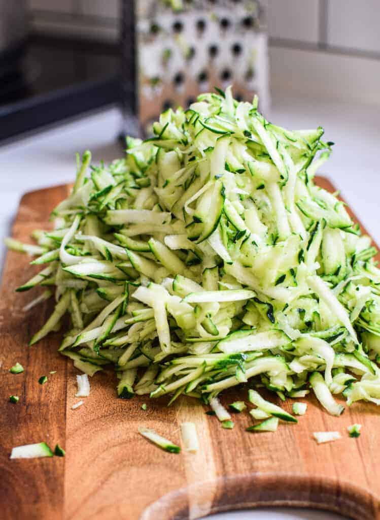 grated zucchini on a wooden chopping board 