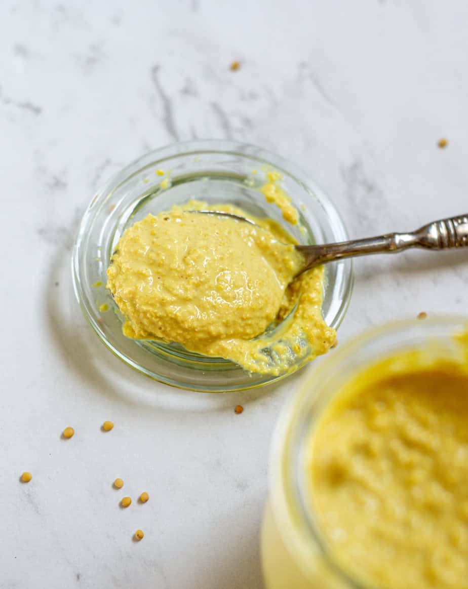 a spoonful of homemade yellow mustard on a glass dish