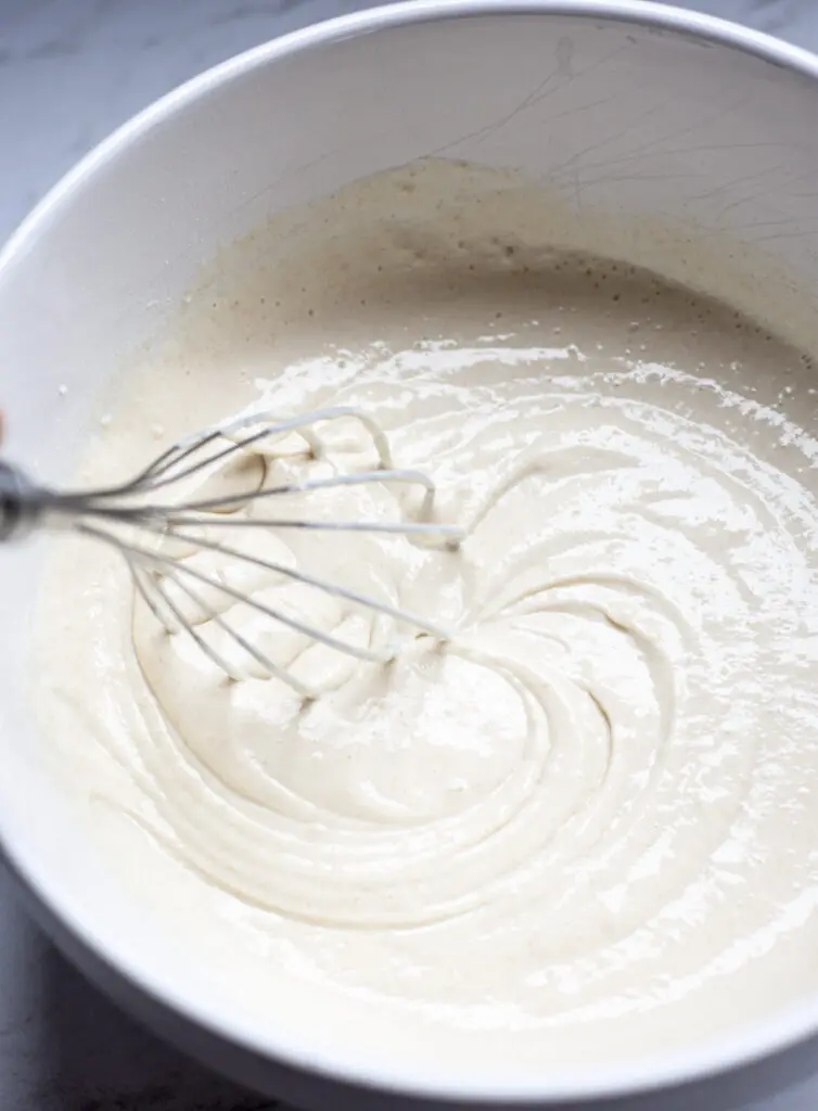 a bowl of pancake batter with a whisk