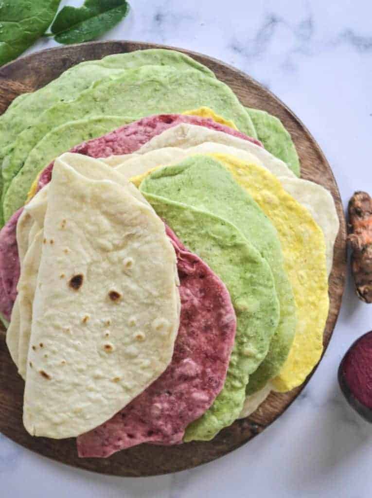 a stack of coloured tortillas on a brown board