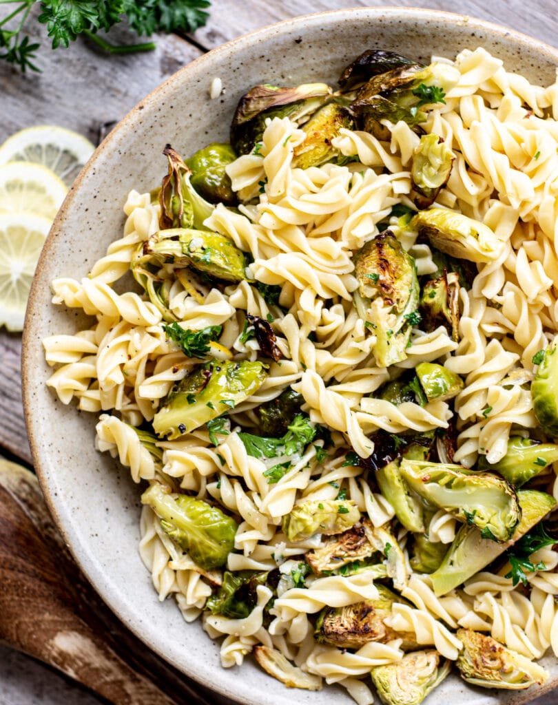 a bird' eye view of a bowl of fusilli pasta with roasted Brussels sprouts and lemon
