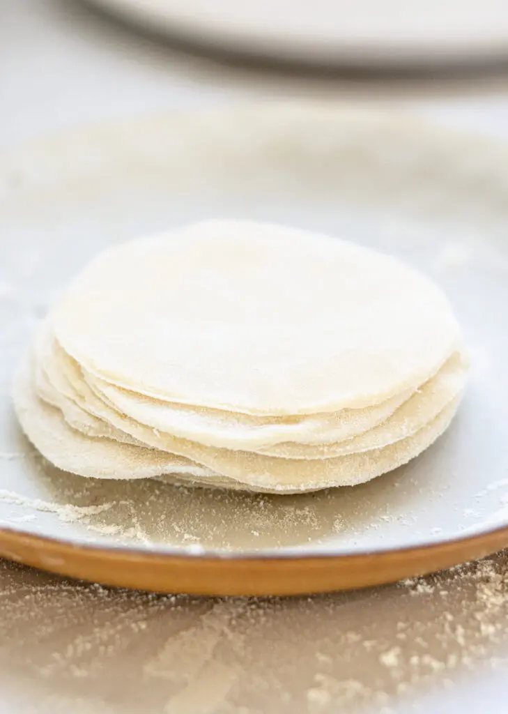 a stack of dumpling wrappers on a white plate
