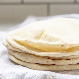 a stack of sourdough pita bread on a tea towel