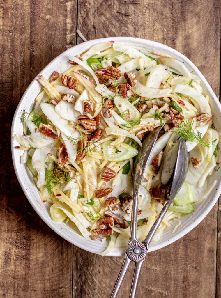 fennel salad with pecans in a white bowl