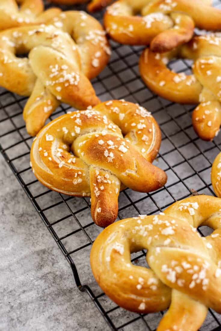 golden pretzels on a black rack with coarse salt