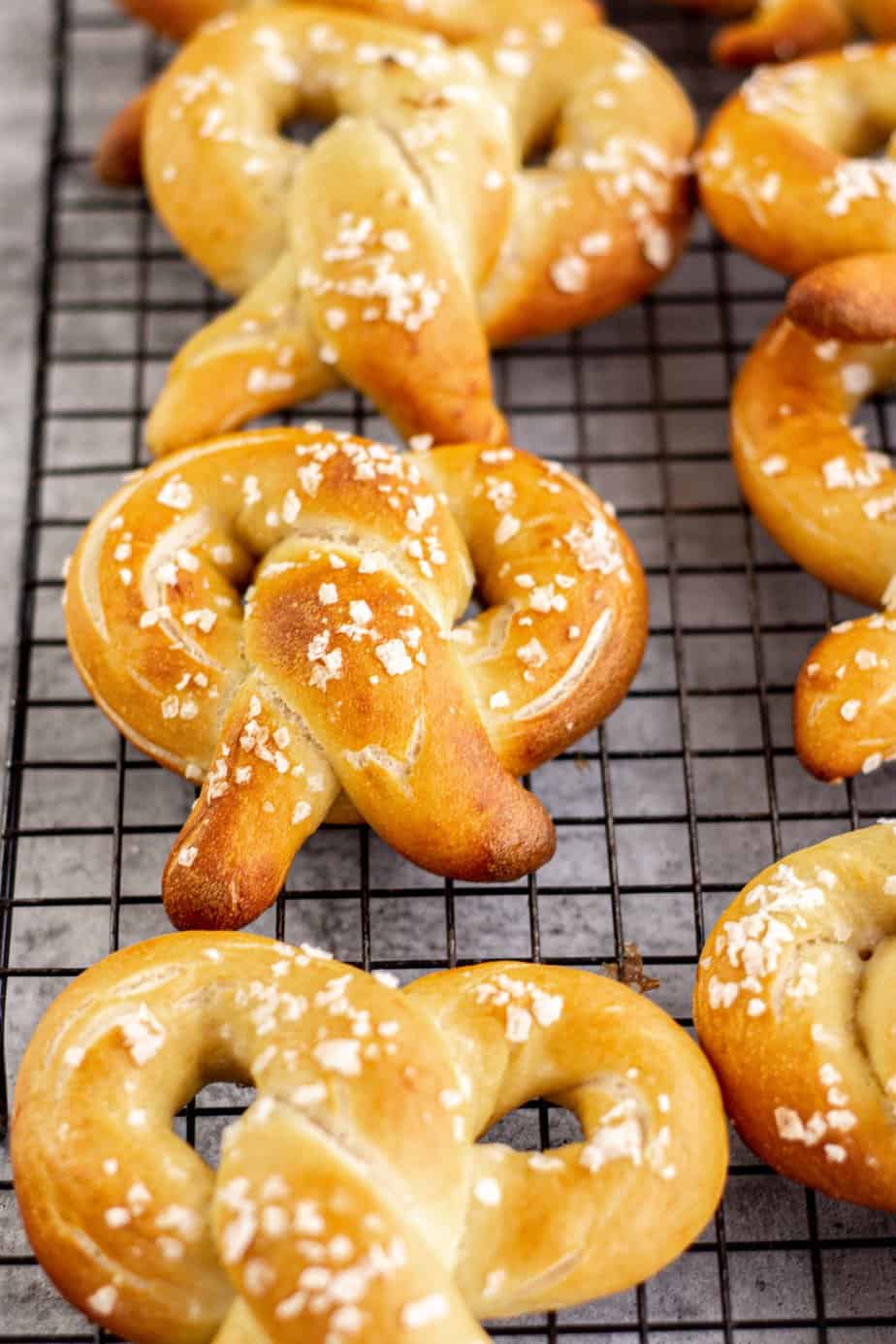 golden sourdough pretzels on a black rack