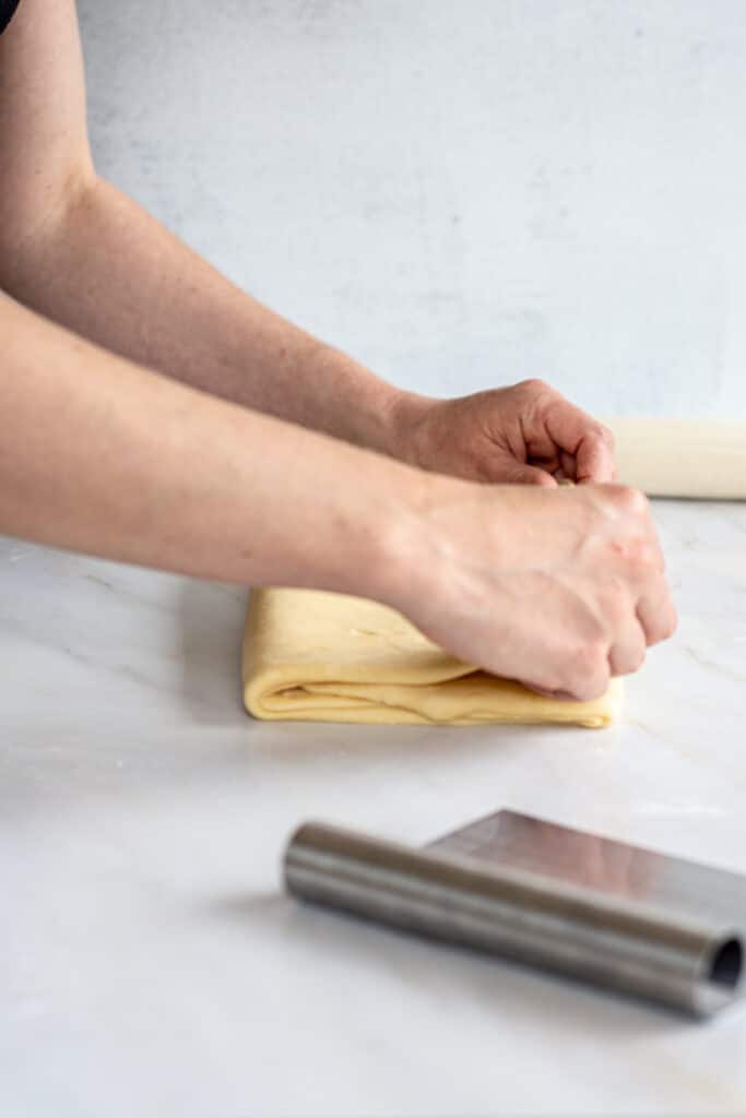 hands folding over dough