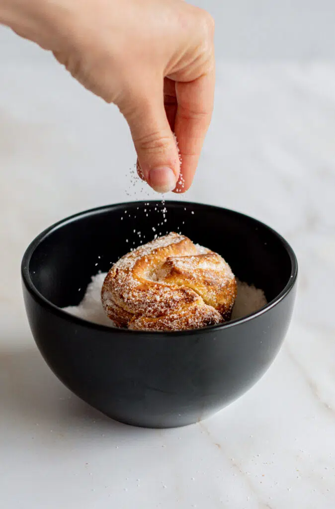 sugar being sprinkled on a cruffin