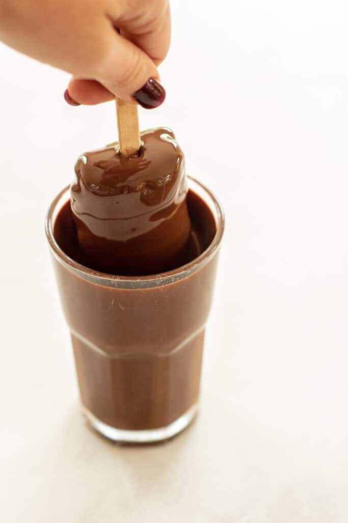 ice cream dipped into glass of chocolate